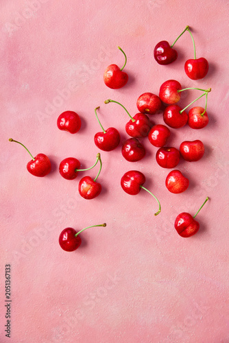 Fresh sweet cherries on pink background, top view. Summer fruit composition with copy space.