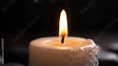 lit candle, flame, white wax, decorative texture, dim background