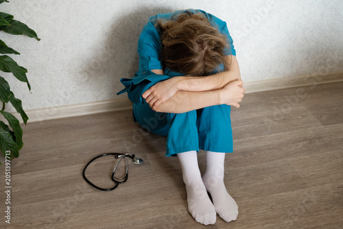 Healthcare worker in distress after a long shift in a medical facility
