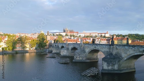 Experience the beauty of Charles Bridge and Prague Castle in a stunning aerial view. The morning light brings out the charm of the Vltava River and historic architecture in Czechia.