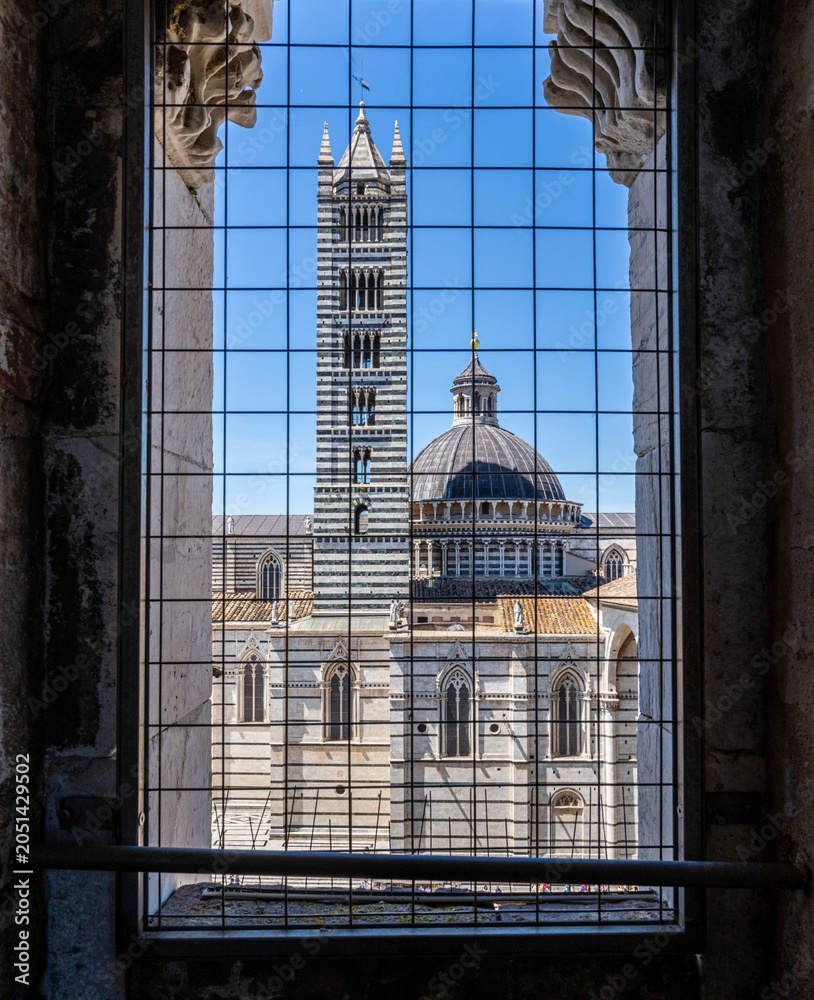 Obraz premium Facciatone, Ausblick durch das Gitter im Turmfenster auf den Duomo di Siena, Toskana, Italien