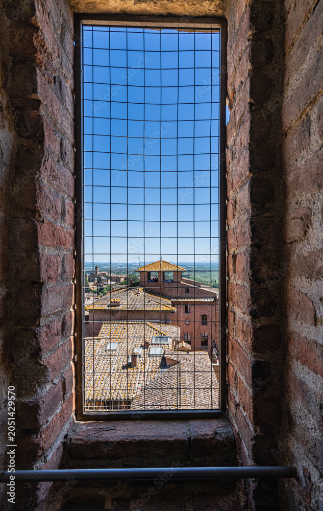 Obraz premium Facciatone, Ausblick durch das Gitter im Turmfenster auf den Duomo di Siena, Toskana, Italien