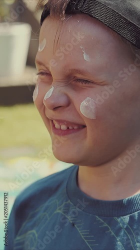 mother applying sunscreen on kids face on sunny summer day. skin protection from sunburn
