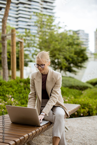 Woman works on laptop in ou...