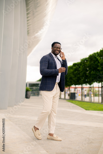 Man in a blazer walks while...