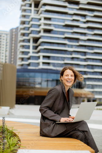 Woman works on laptop outsi...