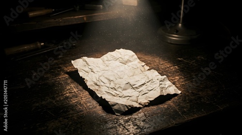 An old crumpled piece of paper rests on a wooden desk under a single spotlight, evoking a sense of mystery and history