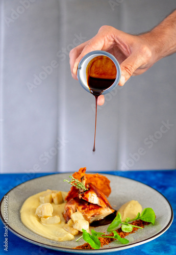 фотографія Deliciously Plated Gourmet Dish With Rich Sauce Pouring Over Tender Chicken