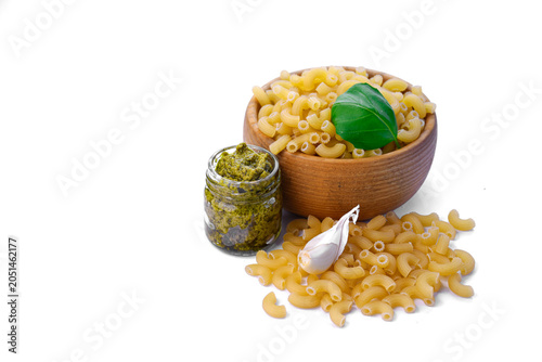 Pasta ingredients with pesto sauce, garlic and basil isolated on light background with copy space