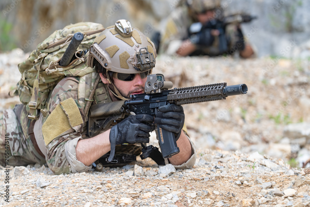 Fototapeta premium Soldier in tactical gear aiming rifle during military training exercise