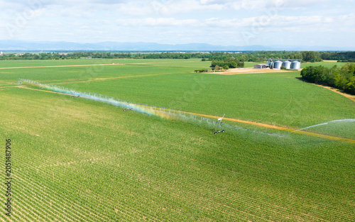 Aerial view of a center pivot irrigation system watering a green agricultural field during the growing season