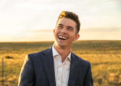 Smiling man in suit outdoors at golden hour