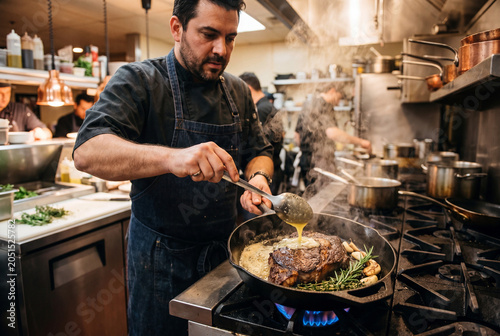 chef basting a steak with melted butter