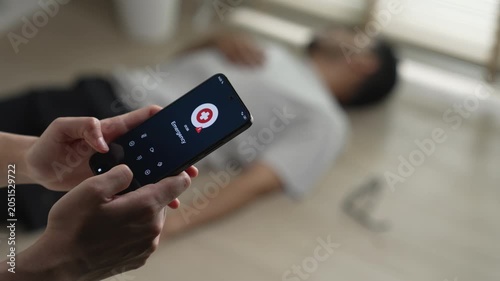 Woman calling emergency service to aid unconscious man lying on the floor