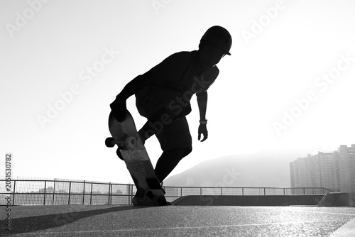 Silhouette of skateboarder performing trick at skatepark