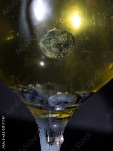 Close-up of a blueberry floating in a glass of white Sangria