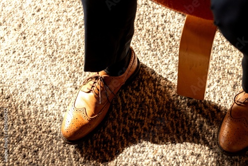 Tableau sur toile Close-up of a person wearing brown leather brogues on a carpeted floor