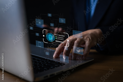 Businessman using laptop with virtual reset password screen interface. Cyber security, privacy data protection and biometric verification concept.