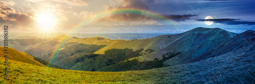 panorama of mountainous landscape. day meet night. wide view of cloudy sky with sun and moon in harmony over the grassy slope of a mountain ridge. epic summer solstice. adventure tourism in highland