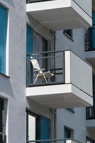 Fassade eines Wohnhauses in Berlin, mit einem bequemen Stuhl auf dem Balkon
