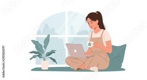 Young woman working on a laptop, holding a cup of coffee, sitting comfortably by a window with plants.