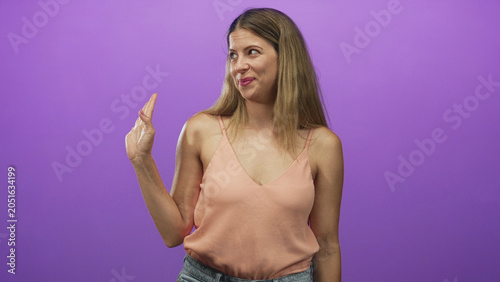 Tableau sur toile Woman hand raised palm facing camera in studio, fingertip to temple then waving off gesture and skeptical face; dismissive attitude