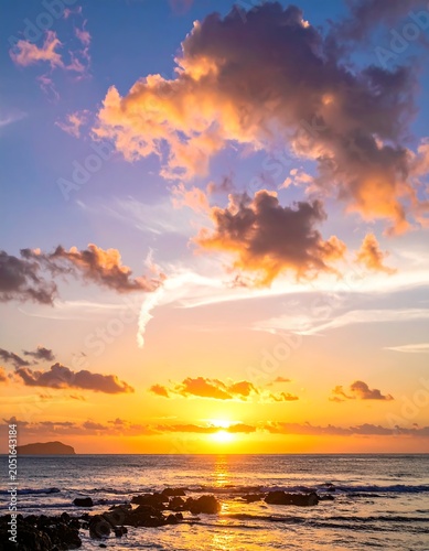 A serene sunset over a calm sea with vibrant orange and blue hues