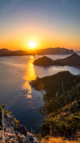 A serene sunset over a tranquil body of water with distant mountains