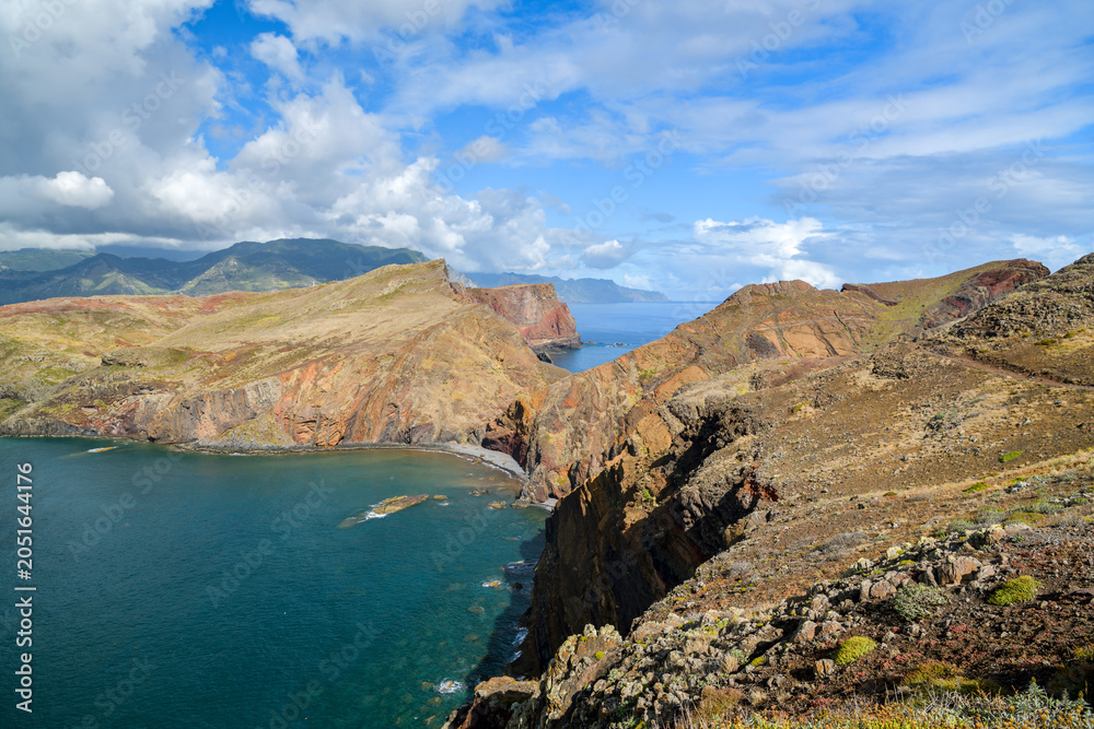 Obraz premium Colorful layered cliffs jutting into turquoise sea