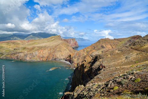 Colorful layered cliffs jutting into turquoise sea