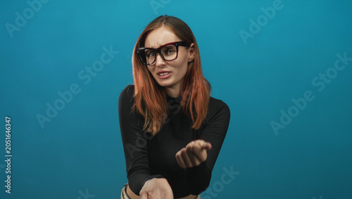 Bild auf Leinwand Woman redhead wearing glasses and black crop top, hands on chest and palms extended offering in studio; apology