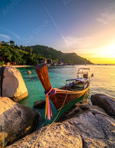 A serene tropical scene with a wooden boat on rocks