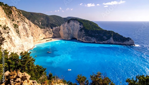 A serene turquoise bay nestled between rugged cliffs and lush greenery