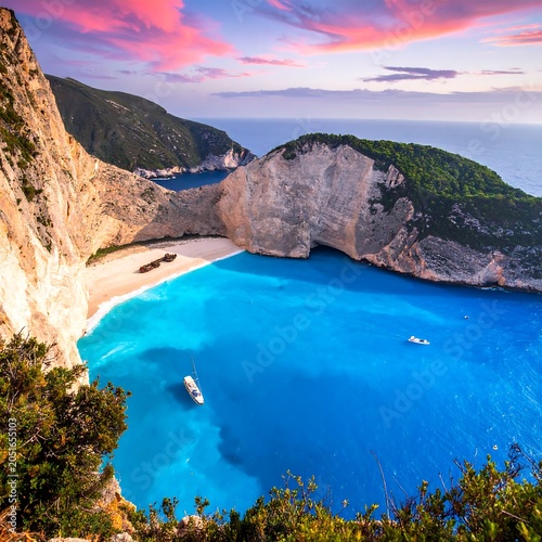 A serene turquoise bay nestled within towering cliffs and lush greenery at sunset