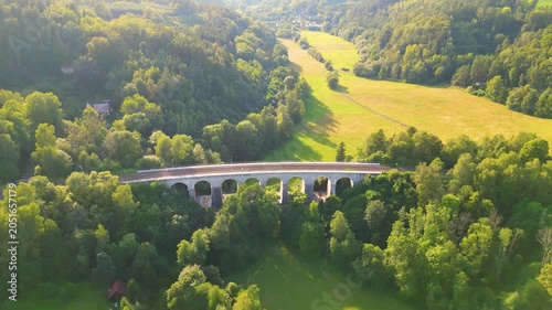 Sychrov Railway Bridge spans a lush valley in Czechia, connecting scenic landscapes and enhancing travel routes. Experience the bridge's impressive structure set against a backdrop of greenery.