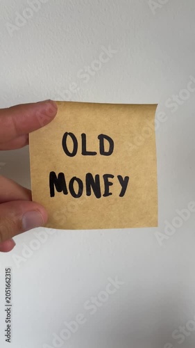 Hand holding kraft paper note with handwritten Old Money message on white background