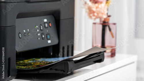 Foto Modern printer outputs colorful photo on desk