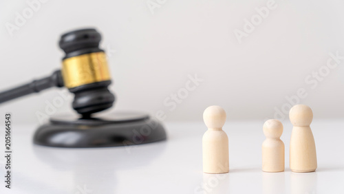 Wooden figures represent a family beside a judge's gavel