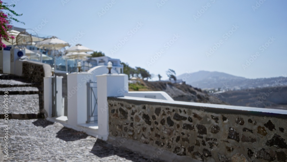 Fototapeta premium Coastal terrace and stone walkway in soft sunlit blurred bokeh, path; background backdrop copyspace calm.