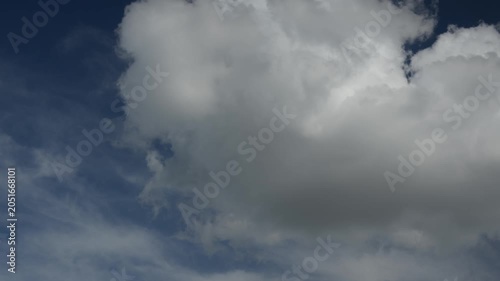 Puffy clouds moving across blue sky timelapse