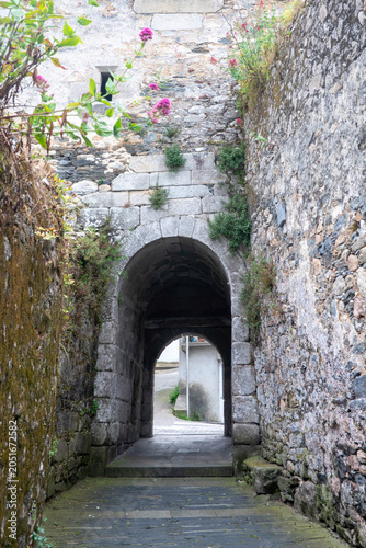The Porta do Valado in Viveiro, Galicia, a Romanesque gate that was part of the medieval walled enclosure. Next to the gate are archaeological remains showing the ancient walls and medieval dwellings.