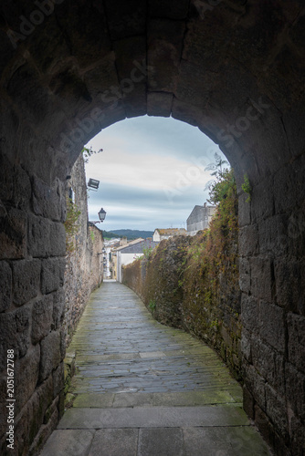 The Porta do Valado in Viveiro, Galicia, a Romanesque gate that was part of the medieval walled enclosure. Next to the gate are archaeological remains showing the ancient walls and medieval dwellings.