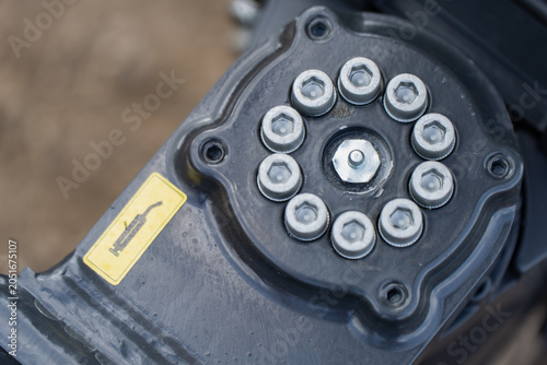 Obraz na płótnie Mechanical greasing point with zinc plated allen bolts and a yellow warning sign