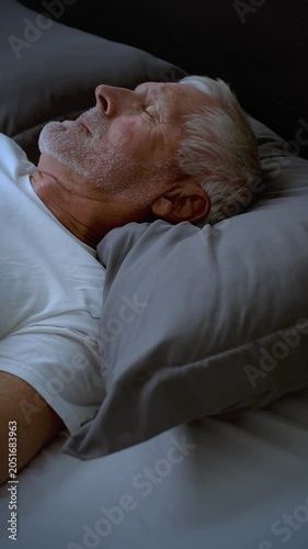 Mature adult sleeping at night. Vertical Video.