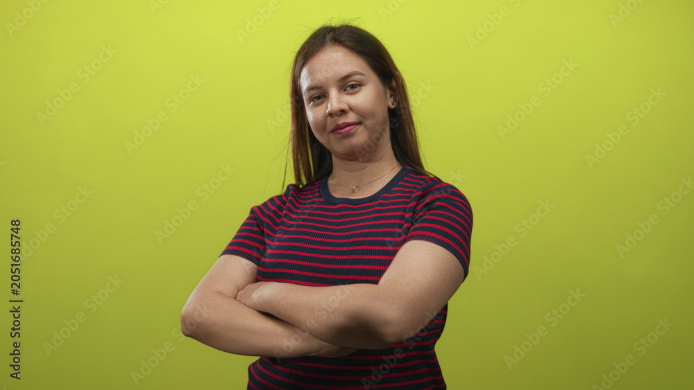 Obraz premium Woman with arms crossed and a thumbs up gesture in a studio with lime green backdrop; confidence approval.
