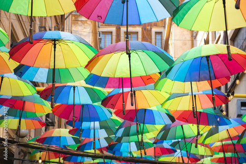 Vibrant display of multicolored umbrellas suspended above a pedestrian street in Bucharest, Romania. Creative urban decoration creating a cheerful atmosphere