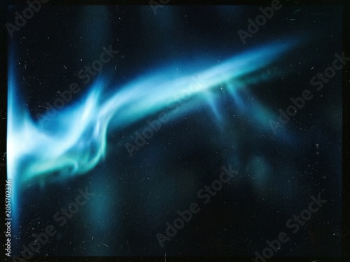 Cool blue light leak on grainy dark background with soft gradient transitions for minimalist graphic design and moody cinematic visual presentations.