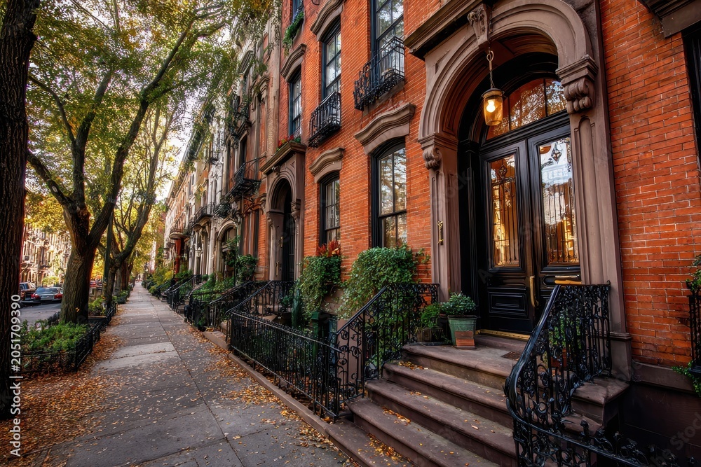 Fototapeta premium Quiet street view of a traditional brownstone home with steps and brick architectural details