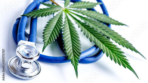 Medical marijuana and stethoscope. Green leaves of cannabis,pills and cbd oil over medical prescription sheet - medical marijuana concept.Selective Focus With Copy Space.