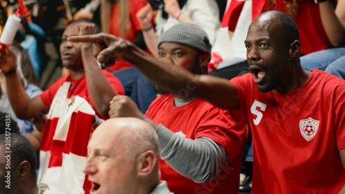 Fotografie Joyful football supporters jumping after winner goal secures world championship victory, thrilling soccer match, cheering crowd with raised fists erupting with fan joy and powerful team spirit